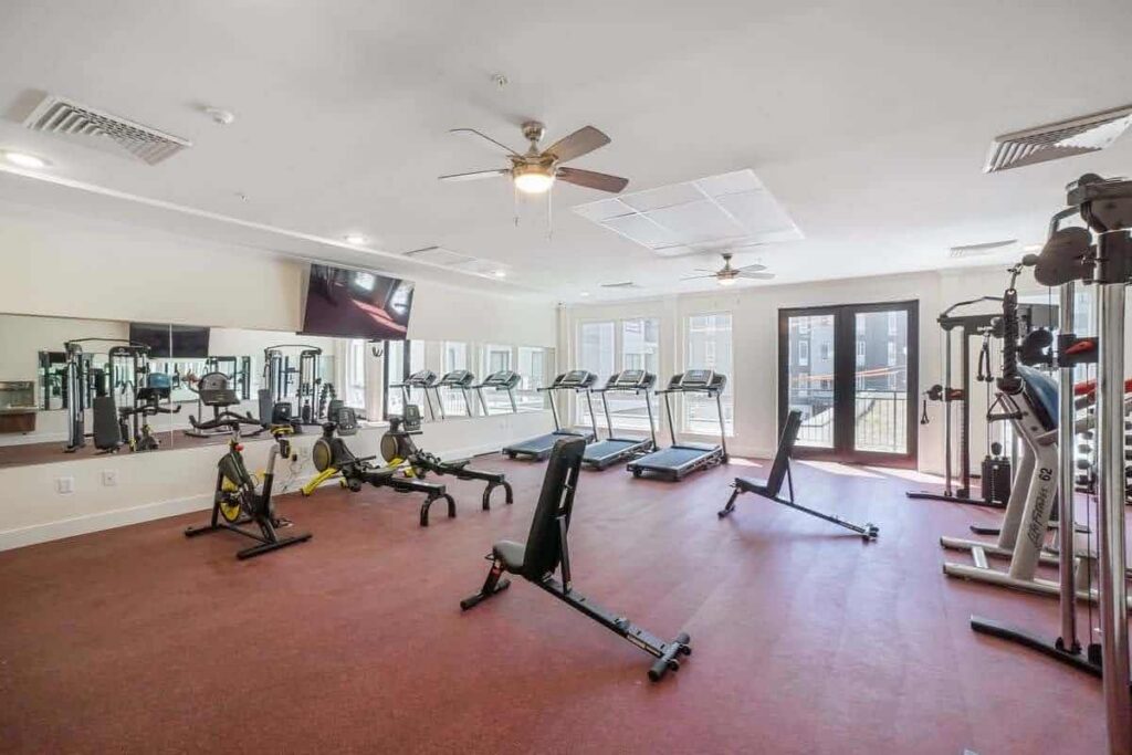 Fitness center at The Mill at York Station featuring treadmills, stationary bikes, weight machines, and mirrored walls